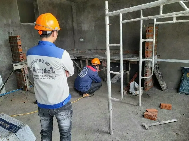 Nhân viên chuyên môn đang xử lý mối bằng thiết bị hiện đại tại nhà Nhân viên chuyên môn đang xử lý mối bằng thiết bị hiện đại tại nhà